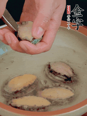 鮑魚加鹽、清水浸泡，用勺子挖出鮑魚肉。