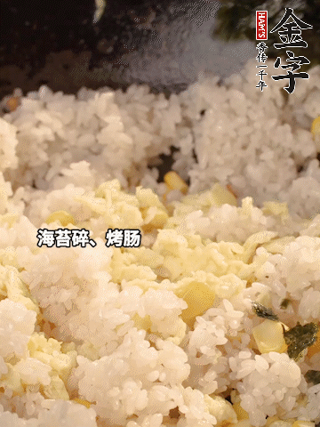 剩米飯下鍋炒散，依次下玉米粒、雞蛋、烤腸、海苔碎翻炒均勻。