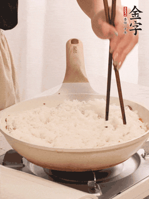 把瀝干水分的米飯均勻鋪在上面，筷子戳幾個洞，以便透氣，轉小火蓋上蓋子燜至水分收干，大概10分鐘。